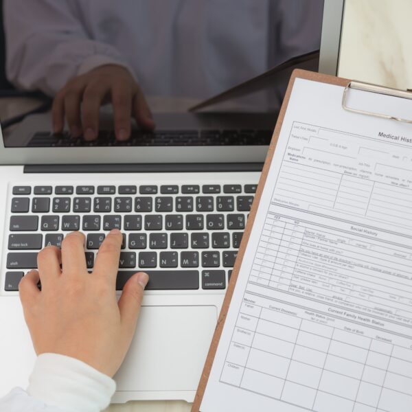 top-view-doctor-using-laptop-clipboard-min